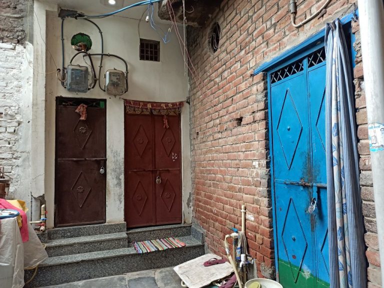 ملزم کا گھر (نیلے دروازے والا) اور متاثرہ خاندان کا گھر۔